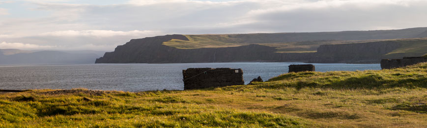 Bild: Steilküste und Ruinen der Fischfabrik bei Skálar